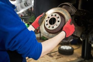 Technician placing brake pad onto a car